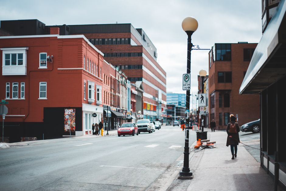 Lively city street scene with buildings and pedestrians on a chilly winter day.
